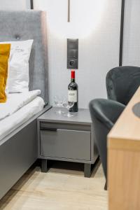 a table with a bottle of wine and glasses on it at S12 Premium Apartments - by Hosty in Krakow
