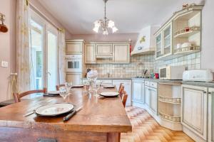 a large kitchen with a wooden table and chairs at Quai secret in Niversac
