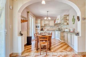 a kitchen with a table and chairs and an archway at Quai secret in Niversac