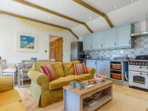 a living room with a yellow couch and a kitchen at 2 Bed in Wadebridge oc-82681 in Little Petherick