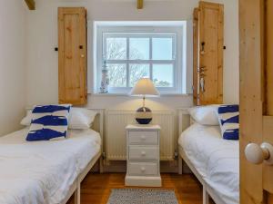 two twin beds in a room with a window at 2 Bed in Wadebridge oc-82681 in Little Petherick