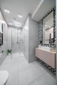 a bathroom with a shower and a sink and a mirror at S12 Premium Apartments - by Hosty in Krakow