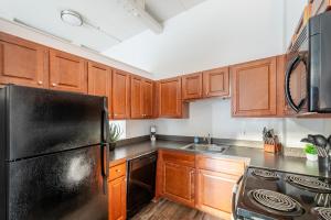 a kitchen with wooden cabinets and a black refrigerator at Landing Apartments - Stockbridge Court in Springfield +18 photos