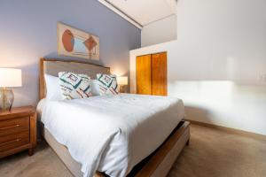 a bedroom with a large white bed and a wooden cabinet at Landing Apartments - Stockbridge Court in Springfield