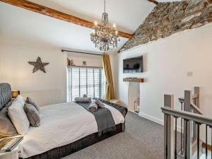 a bedroom with a large bed and a chandelier at 1 Bed in Kendal oc-94210 in Kendal