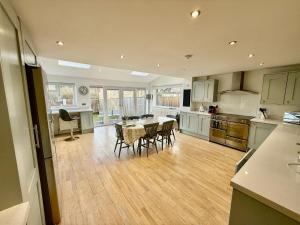 a large kitchen with a table and chairs in it at Oak View - Spacious 3 Bedroom House near Oxford and the Cotswolds in North Leigh