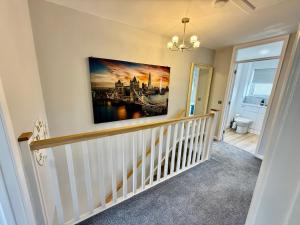 a staircase in a home with a painting on the wall at Oak View - Spacious 3 Bedroom House near Oxford and the Cotswolds in North Leigh