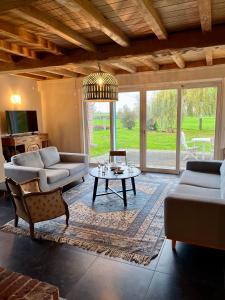 a living room with a couch and a table at La Ferme de Beauvoorde - 13 personnes in Steenvoorde +56 photos