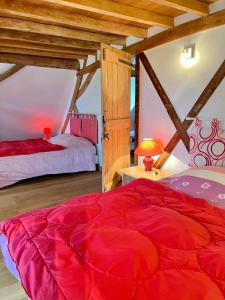 a bedroom with two beds and a red blanket at La Ferme de Beauvoorde - 13 personnes in Steenvoorde