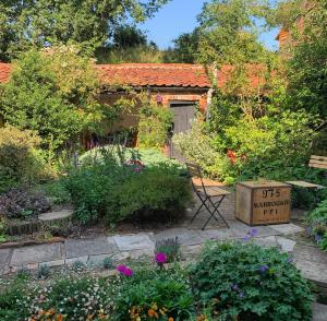 a garden with flowers and a sign in front of a house at The Old Post Box in Holton