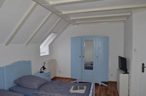 a bedroom with a bed and a blue cabinet at Gästehaus Peter in Mettlach
