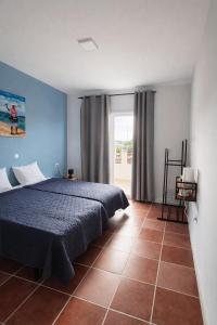 a bedroom with a bed and a large window at Djeu Guest House in Santa Maria