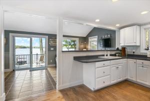 a kitchen with white cabinets and a view of the water at Eagle's Landing Private Dock Dog Friendly in Acton +21 photos