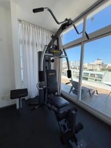 a gym with a treadmill and a chair and a window at Hotel Gema Luxury Suites in Montevideo