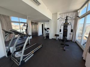 a gym with treadmills and machines in a hotel room at Hotel Gema Luxury Suites in Montevideo