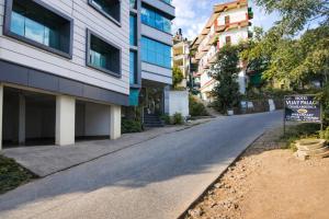 an empty street in a city with buildings at Hotel Vijay Palace Dharamshala Himachal in Dharmsāla +20 photos