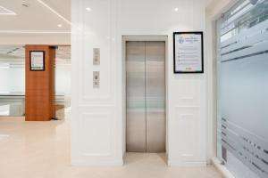 a elevator in a building with a sign on the wall at Treebo Premium Bizz in Ahmedabad +44 photos