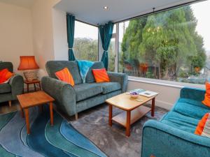 a living room with couches and a large window at Westerlodge in Keswick