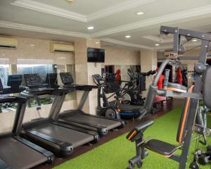 a gym with several treadmills and elliptical machines at Golden Tulip Hotel in Asaba