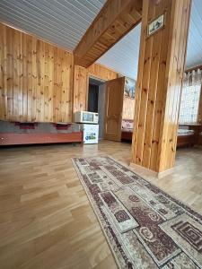 an empty living room with wooden walls and a rug at Заміський будинок кімната студія Pet - friendly in Mukacheve +8 photos