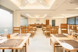 a dining room with wooden tables and chairs at Treebo Premium Bizz in Ahmedabad