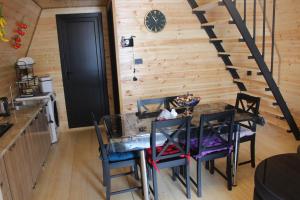 a dining room with a table and chairs and a staircase at Zaga Cottage in Kazbegi