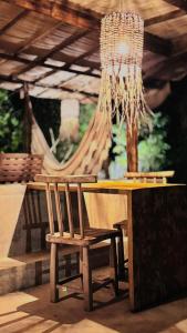 a wooden table with a chair and a chandelier at Kokar Casa Hotel SANTO ANDRÉ in Santo André