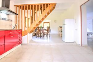 a kitchen with red cabinets and a dining room at Le chalet sur Manoire in Saint-Laurent-sur-Manoire