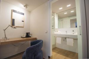 a bathroom with a sink and a desk with a chair at Storni Barcelona by Forget me not in Barcelona +48 photos