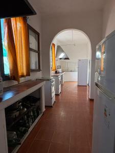 a kitchen with an archway and a kitchen with white appliances at Piriápolis Hostel & suites in Piriápolis