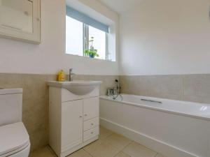a bathroom with a tub and a sink and a toilet at 3 Bed in Bridport oc-dc117 in West Bay +15 photos