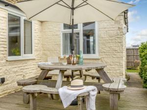 a wooden picnic table with benches and an umbrella at 3 Bed in Bridport oc-dc117 in West Bay