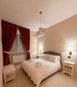 a bedroom with a large white bed with red curtains at B&B Sud Est in Carmiano