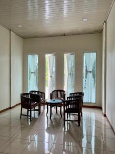 a dining room with a table and chairs and windows at Aurora Hotel Siliwangi in Cirebon