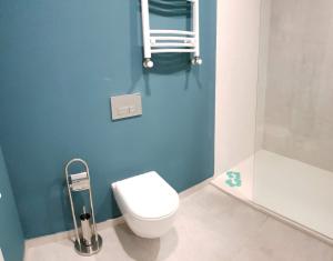 a bathroom with a toilet and a blue wall at New Gudauri GoodHost Apartments in Gudauri