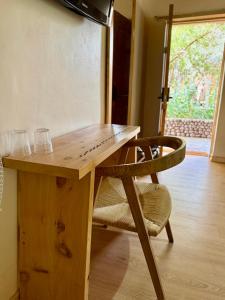 ein Holztisch und ein Stuhl mit zwei Gläsern darauf in der Unterkunft Hotel Jireh in San Pedro de Atacama