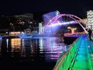 a bridge over a body of water at night at Dongpirang Purple House 1 in Tongyeong
