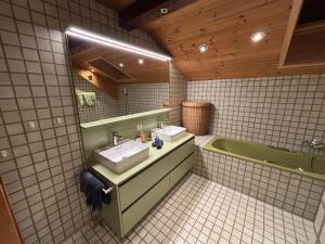 ein Badezimmer mit zwei Waschbecken und einer Badewanne in der Unterkunft Chasa Rontsch Madlaina in Scuol