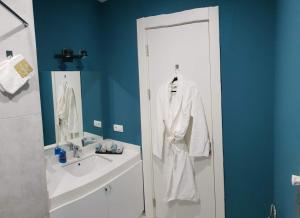 a bathroom with a white robe hanging on a door at New Gudauri GoodHost Apartments in Gudauri