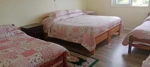 a bedroom with two beds with red and white blankets at Hospedaje Campestre Ranco Naturaleza - Desayuno incluido in Lago Ranco