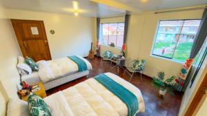 a bedroom with a bed and a couch and a window at Apart Hotel de Alegria in Cusco