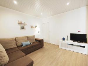 a living room with a couch and a flat screen tv at Casa do Portinho - Sea View House - in São Roque