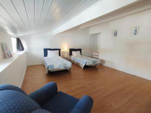 a living room with two beds and a couch at Casa do Portinho - Sea View House - in São Roque