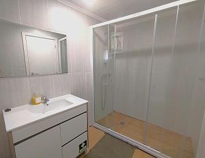 a bathroom with a shower and a sink and a mirror at Casa do Portinho - Sea View House - in São Roque +12 photos