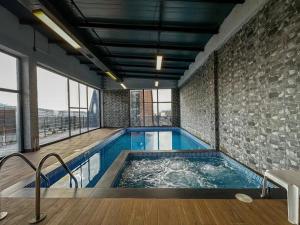 a large indoor swimming pool with a brick wall at Chopan Resort Aparan in Aparan
