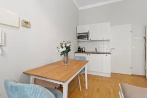 a kitchen with a table with a vase of flowers on it at Bright City Hideaway, Augarten and Danube - 5 min Metro - 10 min Center in Vienna