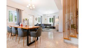 a dining room and living room with a table and chairs at Ruvelis private pool villa in Fiolítis