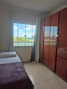 a bedroom with a bed and a large window at Casa Central Super Conforto 78 in Ponta Grossa