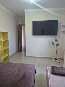 a bedroom with a flat screen tv on the wall at Casa Central Super Conforto 78 in Ponta Grossa