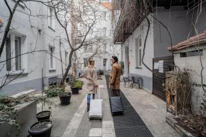 two people walking down a street with luggage at S12 Premium Apartments - by Hosty in Krakow
